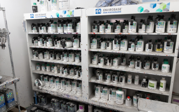 Shelves stocked with various bottles of PPG Envirobase paint products, organized neatly in a workspace.