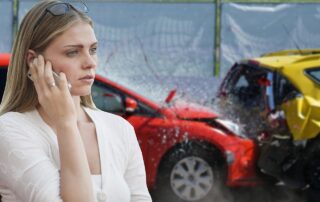 A woman stands in the foreground making a phone call, with two cars visibly damaged from a rear-end collision in the background.